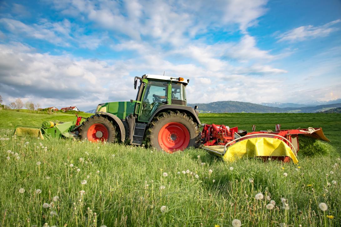 Ein Traktor, der eine Wiese mäht.