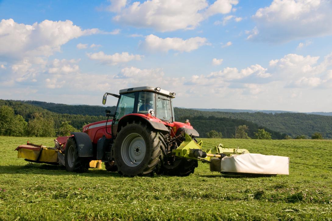 Ein Traktor mit Mähwerk bei der Heuernte.