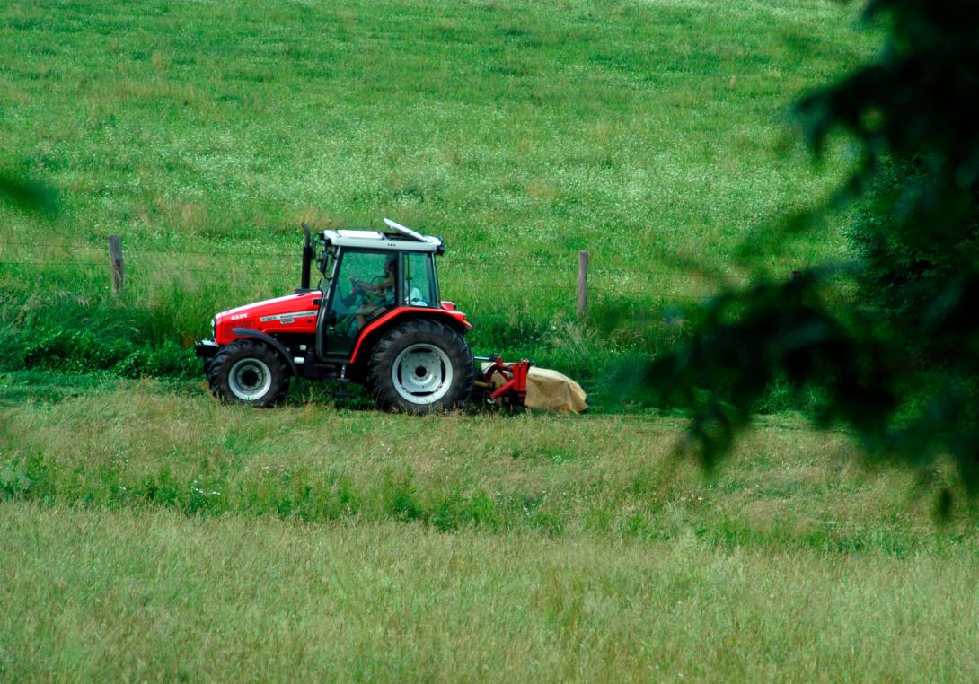 Ein Traktor, der eine Wiese mäht.