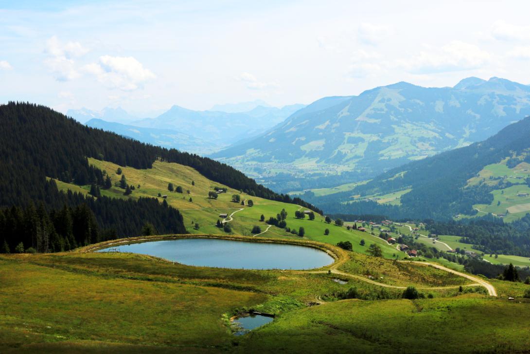 Ein Speichersee in Tirol, im Hintergund sind Berge und ein Tal zu erkennen