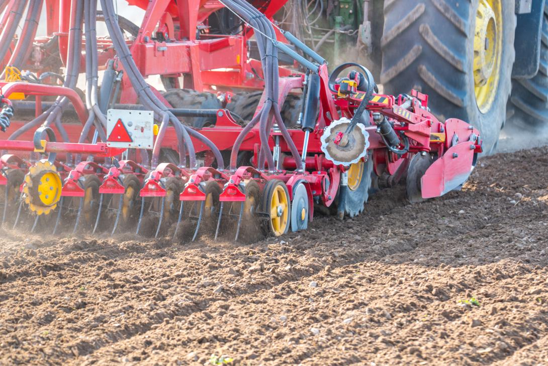 Traktor beim Eggen des Feldes