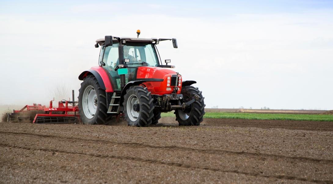 Vorbereitung des Bodens für die Aussaat im Frühjahr, Landwirt im Traktor 