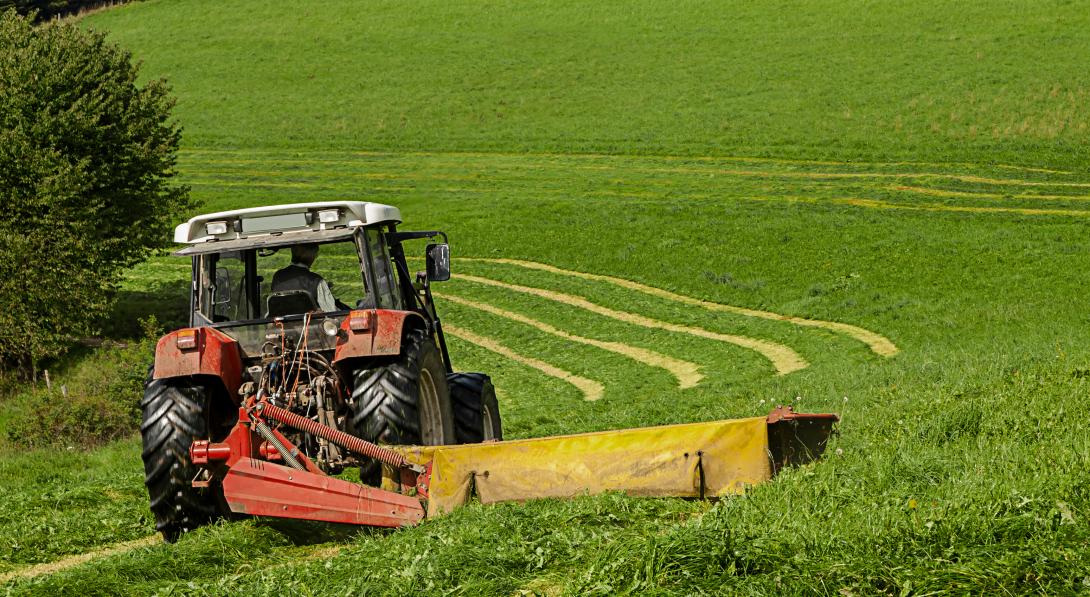 Ein Traktor beim Mähen einer Wiese